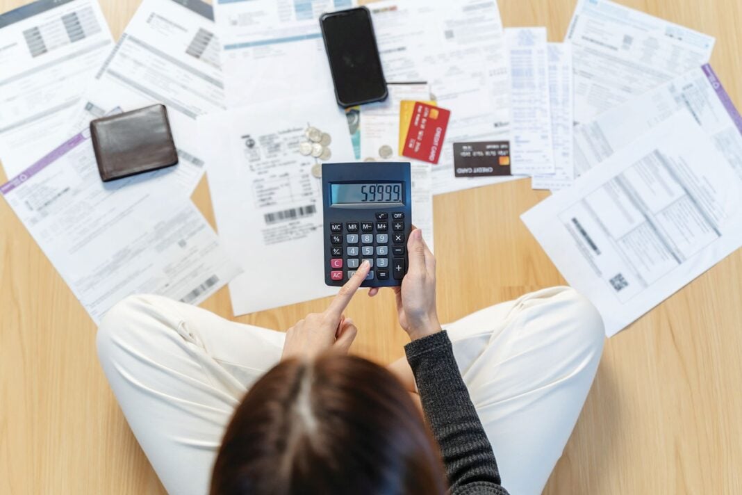 Sad,Asian,Woman,Looking,At,Many,Credit,Cards,In,Her