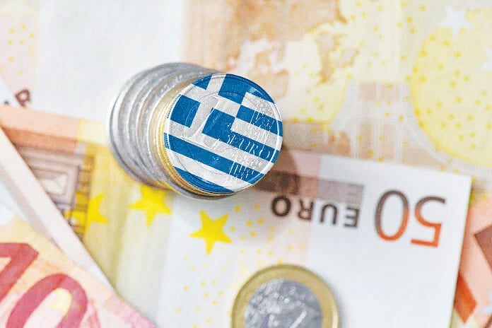 Μετρητά και κέρματα, με την ελληνική σημαία πάνω Μετρητά και κέρματα, με την ελληνική σημαία πάνω