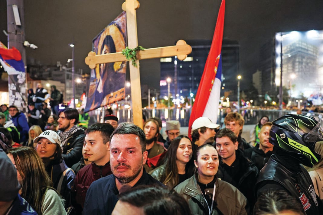 Πλήθος διαδηλωτών στους δρόμους του Βελιγραδίου, με σερβικές σημαίες, θρησκευτικά λάβαρα και έναν μεγάλο ξύλινο σταυρό, σε μια κινητοποίηση που αναδεικνύει τον έντονο πατριωτικό και θρησκευτικό χαρακτήρα της σερβικής κοινωνίας Πλήθος διαδηλωτών στους δρόμους του Βελιγραδίου, με σερβικές σημαίες, θρησκευτικά λάβαρα και έναν μεγάλο ξύλινο σταυρό, σε μια κινητοποίηση που αναδεικνύει τον έντονο πατριωτικό και θρησκευτικό χαρακτήρα της σερβικής κοινωνίας